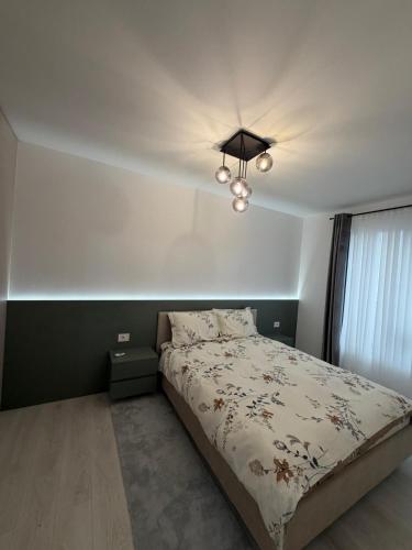 a bedroom with a bed and a chandelier at Deluxe 3 in Timişoara