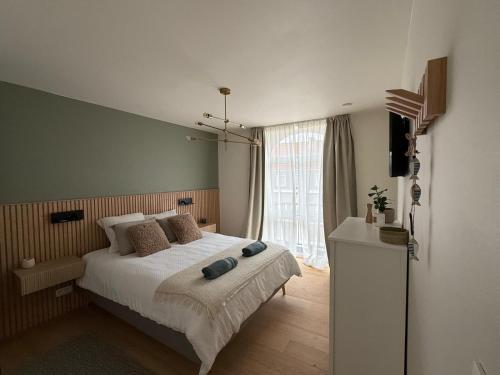 a bedroom with a bed and a large window at De Bakelijn in Nieuwpoort