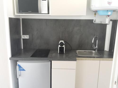 a small kitchen with white cabinets and a sink at Studio Grasse Centre in Grasse