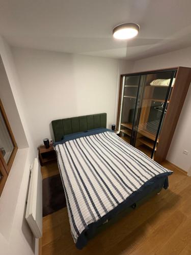 a bedroom with a bed with a striped blanket at Maya 2 apartman sa dve spavace sobe in Vrnjačka Banja