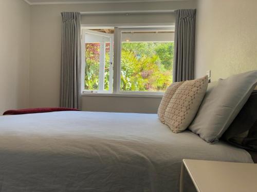 a bedroom with a large bed with a window at Relax in the Garden Suite in Thames