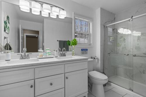 a bathroom with two sinks and a shower and a toilet at Evergreen Villa Poconos - Hot Tub, Fire Pit, Close to Kalahari, Great Wolf Lodge and Camelback in Tobyhanna