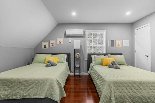 a bedroom with two beds with green comforters at Evergreen Villa Poconos - Hot Tub, Fire Pit, Close to Kalahari, Great Wolf Lodge and Camelback in Tobyhanna