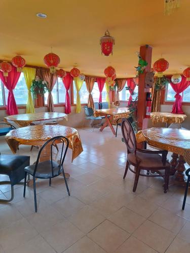 a restaurant with tables and chairs and red curtains at Hospedaje Barato Mi Casita de Colores in Tijuana