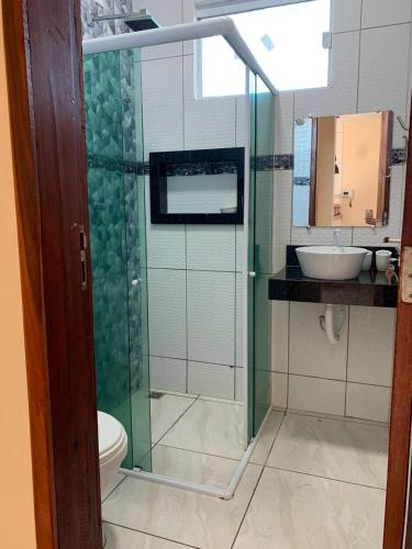 a bathroom with a shower with a toilet and a sink at Casa Camocim Marilago in Camocim