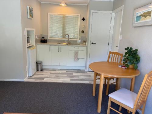 a kitchen with a table and chairs and a sink at Relax in the Garden Suite in Thames