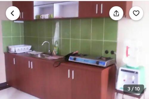 a kitchen with green tiles on the wall and a sink at Villa Oentoeng 1 Private Pool 3 Kamar in Punten