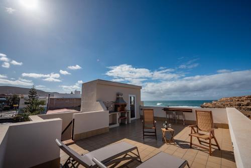 a balcony with chairs and a view of the ocean at Terregal in Ajuy