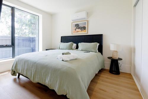 a bedroom with a large bed with a large window at Splendid Spacious - Port Melbourne Beachside Home in Melbourne