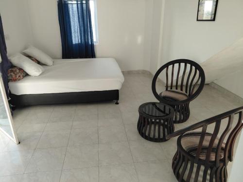 a small room with a bed and two chairs at Lovely beach hotel in Negombo