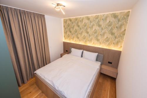 a small bedroom with a bed and a painting on the wall at The Watermill Lodge in Kolašin