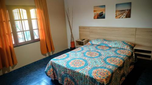 a bedroom with a bed with a colorful comforter at Buon Riposo in Córdoba