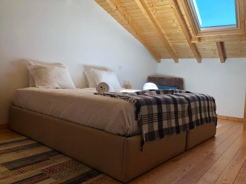 a large bed in a room with a window at Casa de Xisto Ti Maria in Videmonte