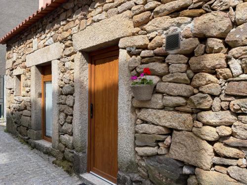 a stone building with a door and a flower pot on it at Casa de Xisto Ti Maria in Videmonte