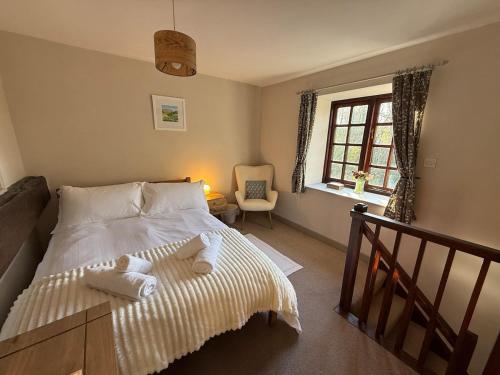 a bedroom with a bed with towels on it at 2 Nookdales Cottages in Ingleton