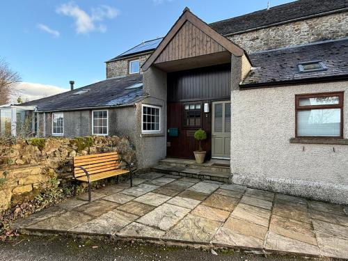 a house with a bench in front of it at 2 Nookdales Cottages in Ingleton