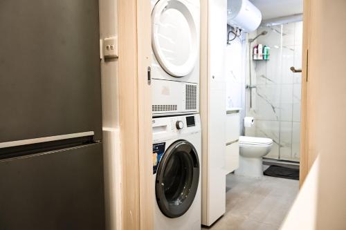 a washing machine in a bathroom with a toilet at 10 Msida Park Residence in Msida