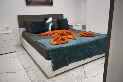 a bed with orange pillows on it in a room at 10 Msida Park Residence in Msida