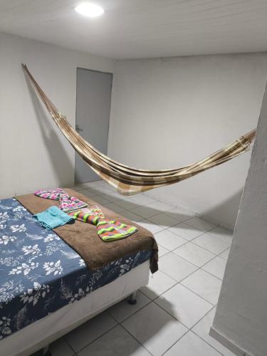 a room with a bed and a hammock in it at Pousada Ouro branco Mossoró RN in Mossoró