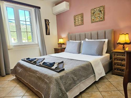 una camera da letto con un grande letto e due lampade di Captain's Loft Villa a Marathokampos