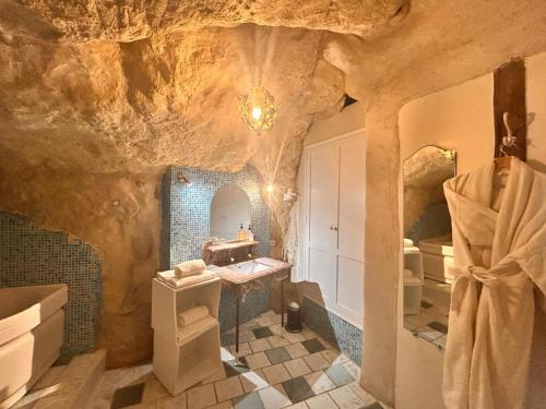 a bathroom with a cave style bathroom with a sink at Logis Hotel Demeure de la Vignole in Turquant
