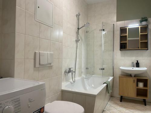 a bathroom with a tub and a toilet and a sink at Gassenzauber in Pirna