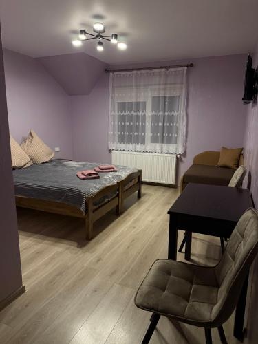a room with a bed and a chair and a table at Садиба KAMALOVA in Yasinya