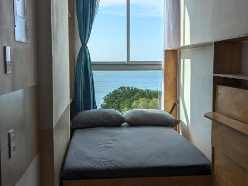 a bed in a room with a large window at Aparta Suite Vista al Mar Rodadero in Gaira