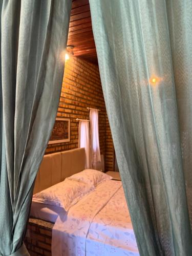 a bedroom with a bed with blue curtains at Incanto in Niterói