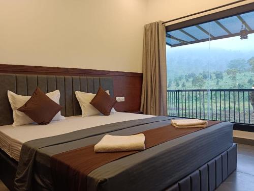 a bedroom with a large bed with a large window at Teaside Inns in Vythiri