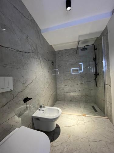 a bathroom with a white toilet and a shower at Bega's BDuplex in Golem, Durrës in Golem