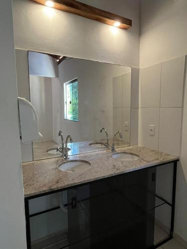 a bathroom with two sinks and a large mirror at Pousada Leve Mar in Ilhéus