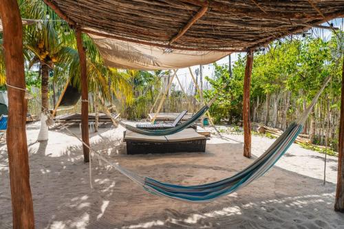 two hammocks in a pavilion on a beach at Camping, Glamping y Caravanas Dos Lunas in Celestún