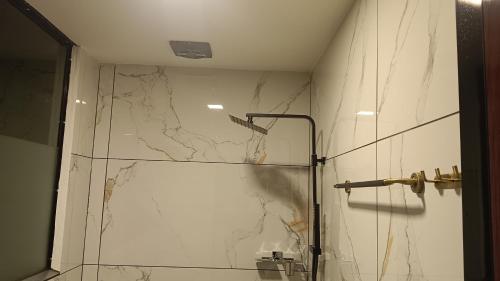 a shower with a glass door in a bathroom at Teaside Inns in Vythiri