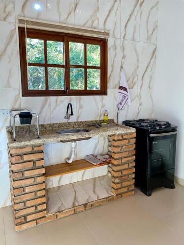 a kitchen with a counter and a stove in it at Casa Lilás no Vale do Capão in Vale do Capao