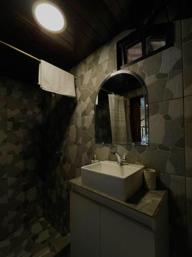 a bathroom with a sink and a mirror at Cabaña en Chachimbiro in Hacienda San Francisco