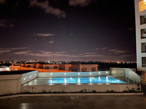 a building with a swimming pool at night at Ocean Breeze Apartment in Maputo