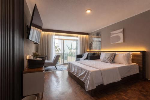 a bedroom with a bed and a large window at Miranthia Hotel Business and family in Cuernavaca