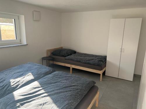 a bedroom with two beds and a cabinet and a window at Gästehaus Wain I Monteur- & Ferienwohnung für 5 I 2 SZ I Terrasse I Parkplatz I WLAN in Wain