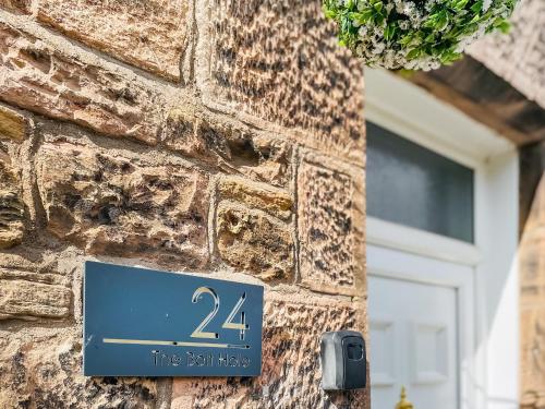 a blue sign on the side of a brick building at The Bolt Hole in Wooler