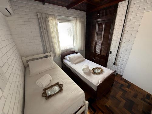 two beds in a small room with a window at Gastehaus Watzko in Piçarras