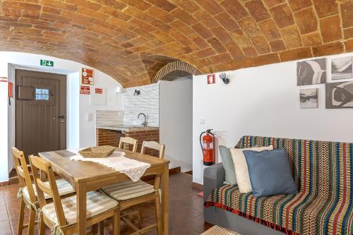 a kitchen and dining room with a table and a couch at Casita dos Avós in Alandroal