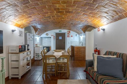 a kitchen and living room with a brick ceiling at Casita dos Avós in Alandroal