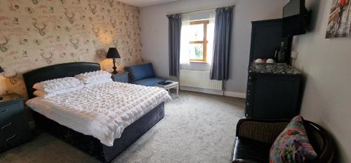 a bedroom with a bed and a chair and a window at Church View House F56H977 in Gorteen