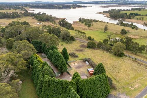 an aerial view of a farm with a train at Serene Farmhouse with Lake Views in Burrawang