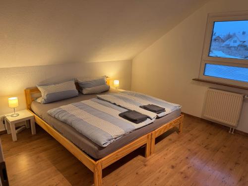 a large bed in a room with a window at Ferienwohnung an der romantischen Straße direkt A3 und A81 in Eisingen