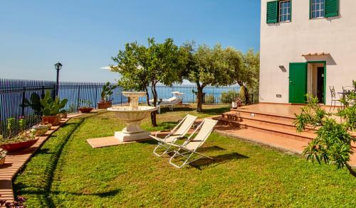 a yard with a chair and a fountain and a building at Villa Il Lupo Felice - Panoramic Sea View Villa, Ravello in Ravello