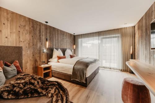 a hotel room with a bed and a couch at Dolomites Chalet Niuasi in Ortisei
