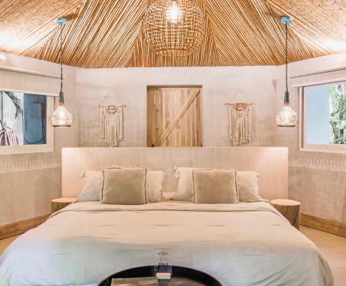 a bedroom with a large bed and pendant lights at Norte Nosara - Steps to Playa Guiones in Nosara