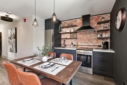 a kitchen with a wooden table and a brick wall at The Brick & Beam Boutique Hotel in Collingwood